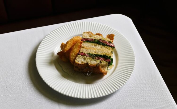 steak sandwich on a white plate