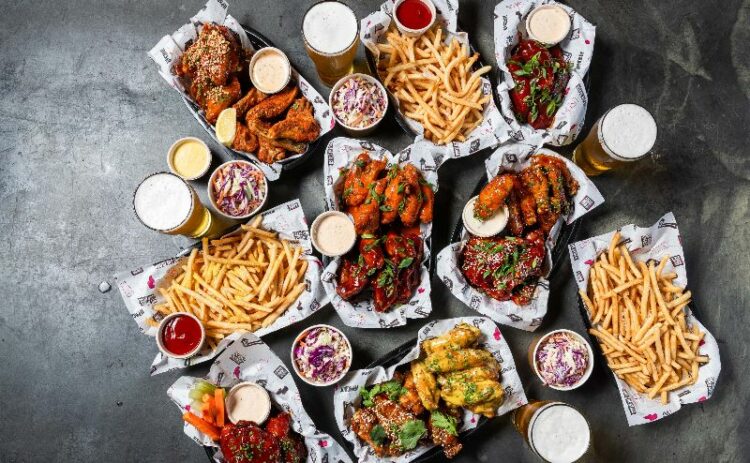 A table full of chicken wings and chips 