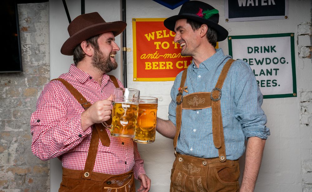 2 men with beer steins dressed in traditional German costume at BrewDog 