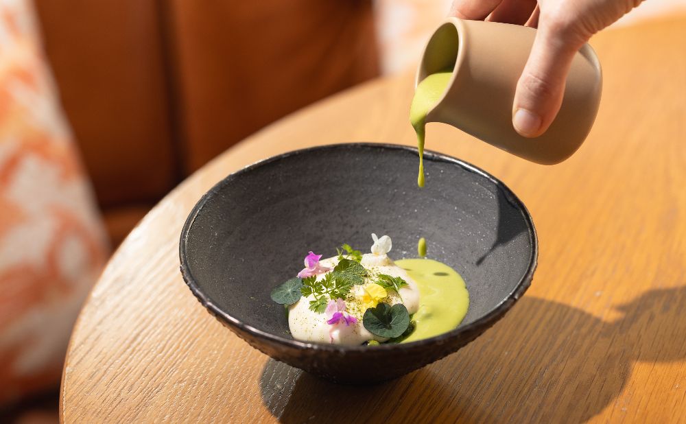 Black bowl with Spring Pea and Garlic Veloute from Sofitel Darling Harbour