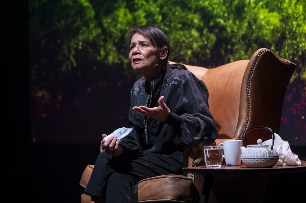 A scene with a woman sitting in a chair next to a pot pf tea - My Cousin Frank credit_Tiffany Garvie