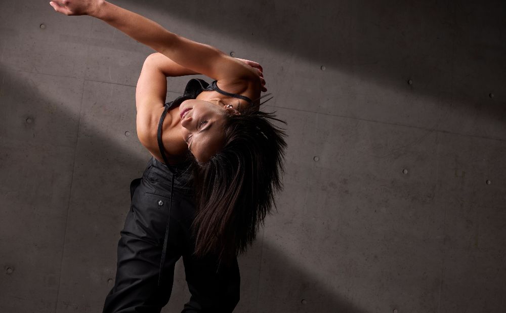 Performance still of a woman with long hair holding a dance pose