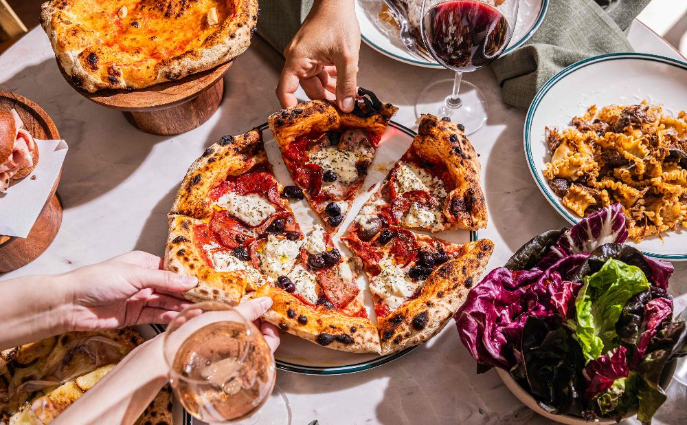 Pizza, pasta and salad on a table at Solana