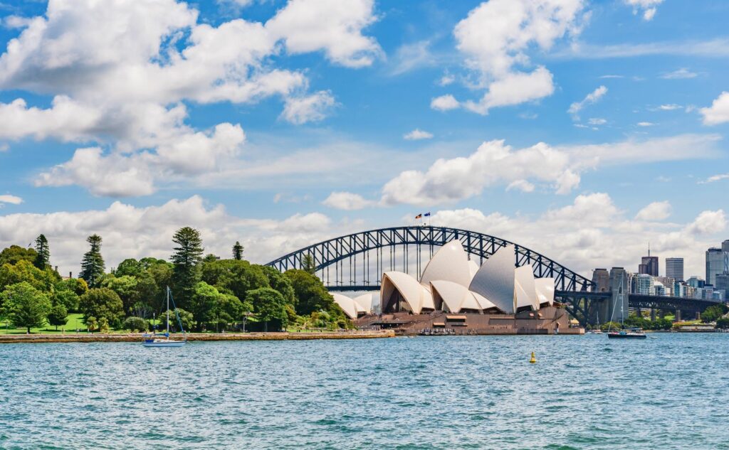 View of Sydney Opera House sitting in front of the harbour bridge taken from the Botanic Garden