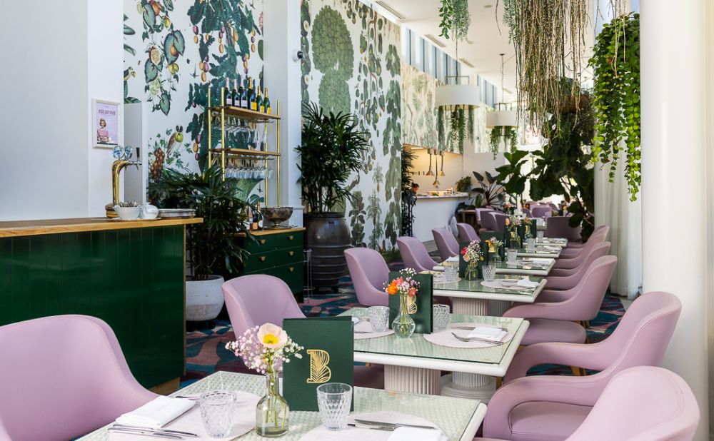 Botanica Vaucluse's beautiful dining room adorned with plants and pink and green decor