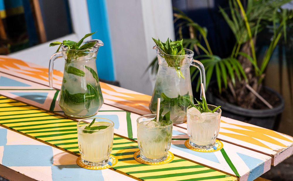 Jugs and glasses of mint mojitos on a painted outdoor table at Rosie Campbell's Surry Hills