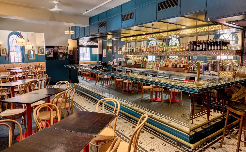 Heritage bar room at The Edinburgh Castle Hotel with teal panelling, tiled floor and bentwood chairs