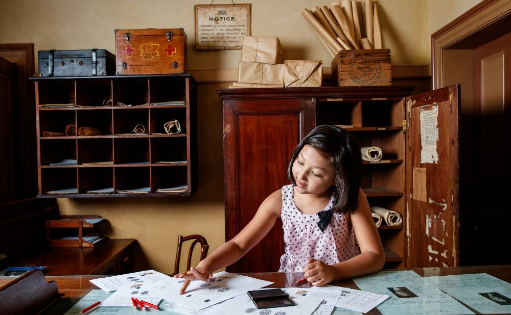 Sasha Sirr absorbed with fingerprinting activities in the Police Station Charge Room of the Justice & Police Museum (c) James Horan for Museums of History NSW 