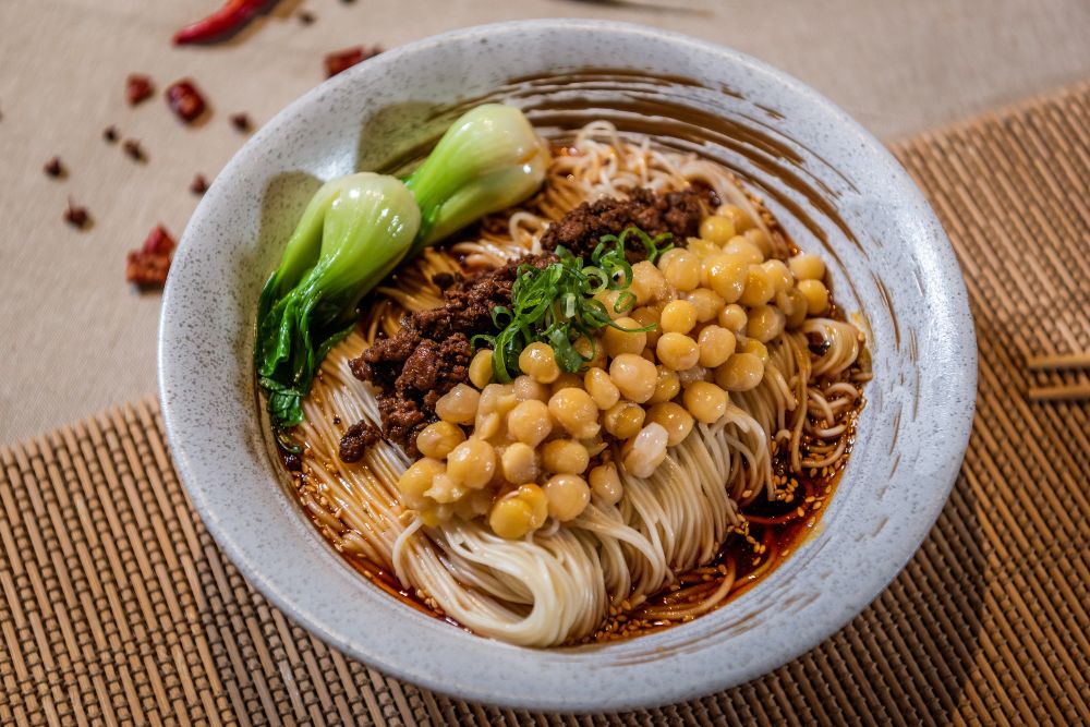 bowl of spicy noodles with vegtables and beef