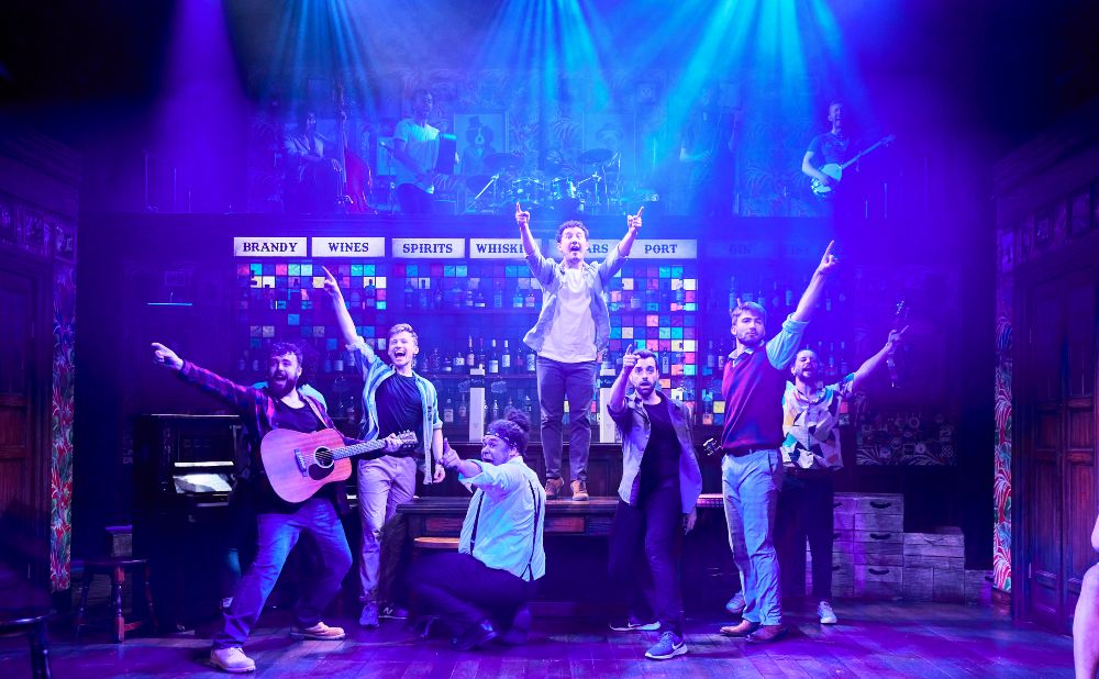 Cast of The Choir of Man singing in a pub set